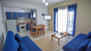 A compact living space with a kitchenette, dining area, and seating area. - The Blue Apartments and Beach (Pangaio)