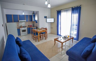 Um espaço compacto com cozinha compacta, área de refeições e espaço para sentar.