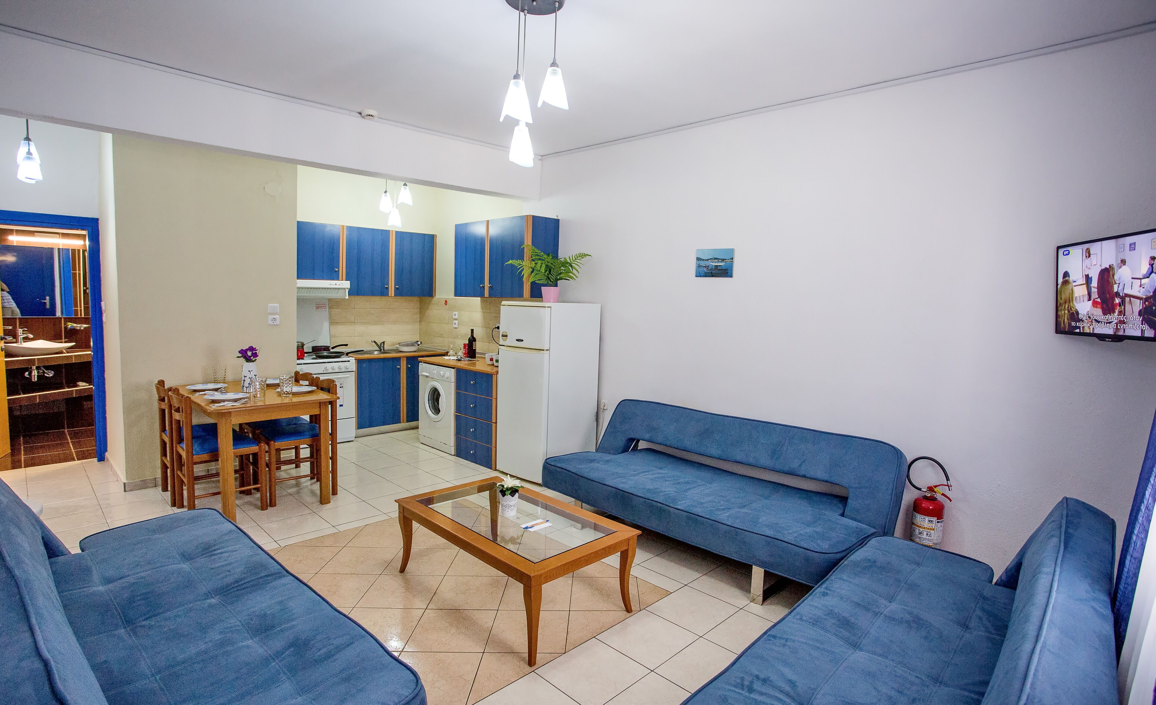 Ein kompakter Wohnraum mit Küchenzeile, Essbereich und einer Sitzecke mit Sofa und Couchtisch.