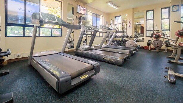 A gym with treadmills, weights, and mirrors. - KenGen Furnished and Serviced Apartments (Nairobi)