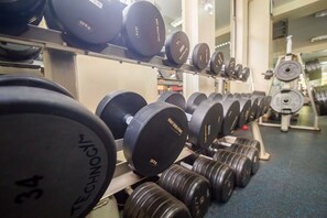 A gym with rows of 10kg and 5kg dumbbells on racks.