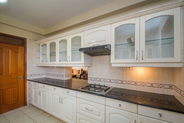 A kitchen with white cabinets, a black countertop, and a gas stove.