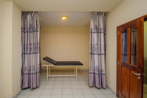 A room with a bed, a bench, and a door.