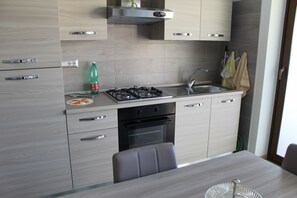 Departamento, vista a la alberca, planta baja | Cocineta privada | Refrigerador, horno, parrilla de estufa y utensilios de cocina 