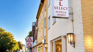 A hotel named 'Hotel Select Suites & Apartments' with a clear sky and a pedestrian sidewalk. - Hotel Select Suites & Aparts (Moenchengladbach)