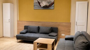A living room with two sofas, a coffee table, and a wall-mounted picture. - Hotel Select Suites & Aparts (Moenchengladbach)