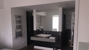 A modern bathroom with a large mirror, a vessel sink, and a towel rack. - Hotel Castellote (Castellote)