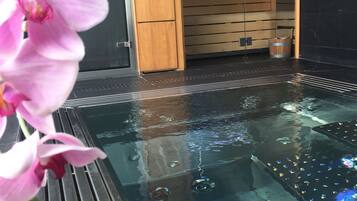Experience serenity with a tranquil water feature and lush greenery.