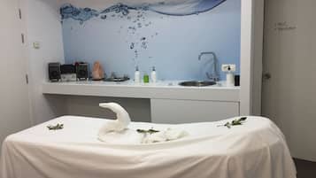 A room with a white table, a sink, and a wall mural.