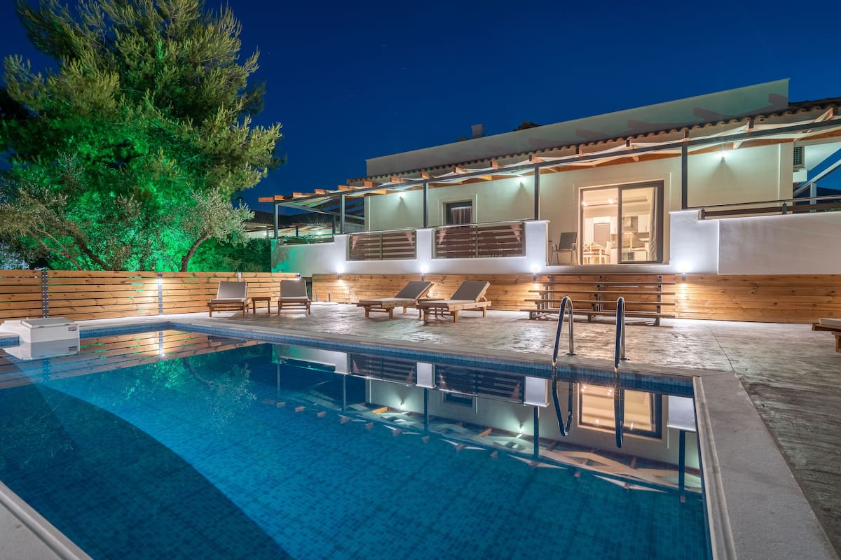 A modern pool area with lounge chairs and a clear pool.