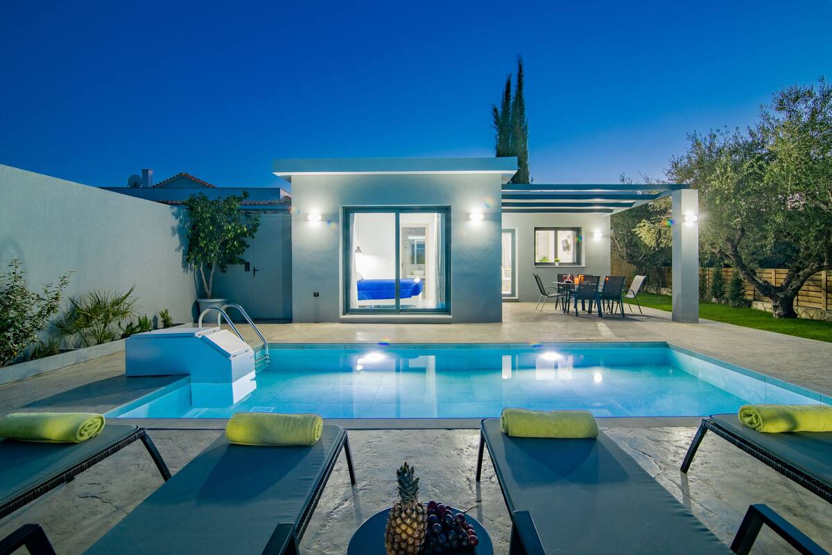 A modern outdoor pool area with lounge chairs and a small pool.