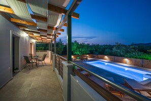 Uma área de piscina no terraço com espaço para refeições e vista para a paisagem ao redor.