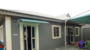 A building with a reception area, a door marked "PUSH," and a covered outdoor seating area with colorful chairs.