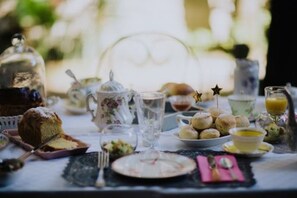 A table set with tea, pastries, and a cake, suggesting a breakfast or tea service. - La Maison Bleue (Villereal)