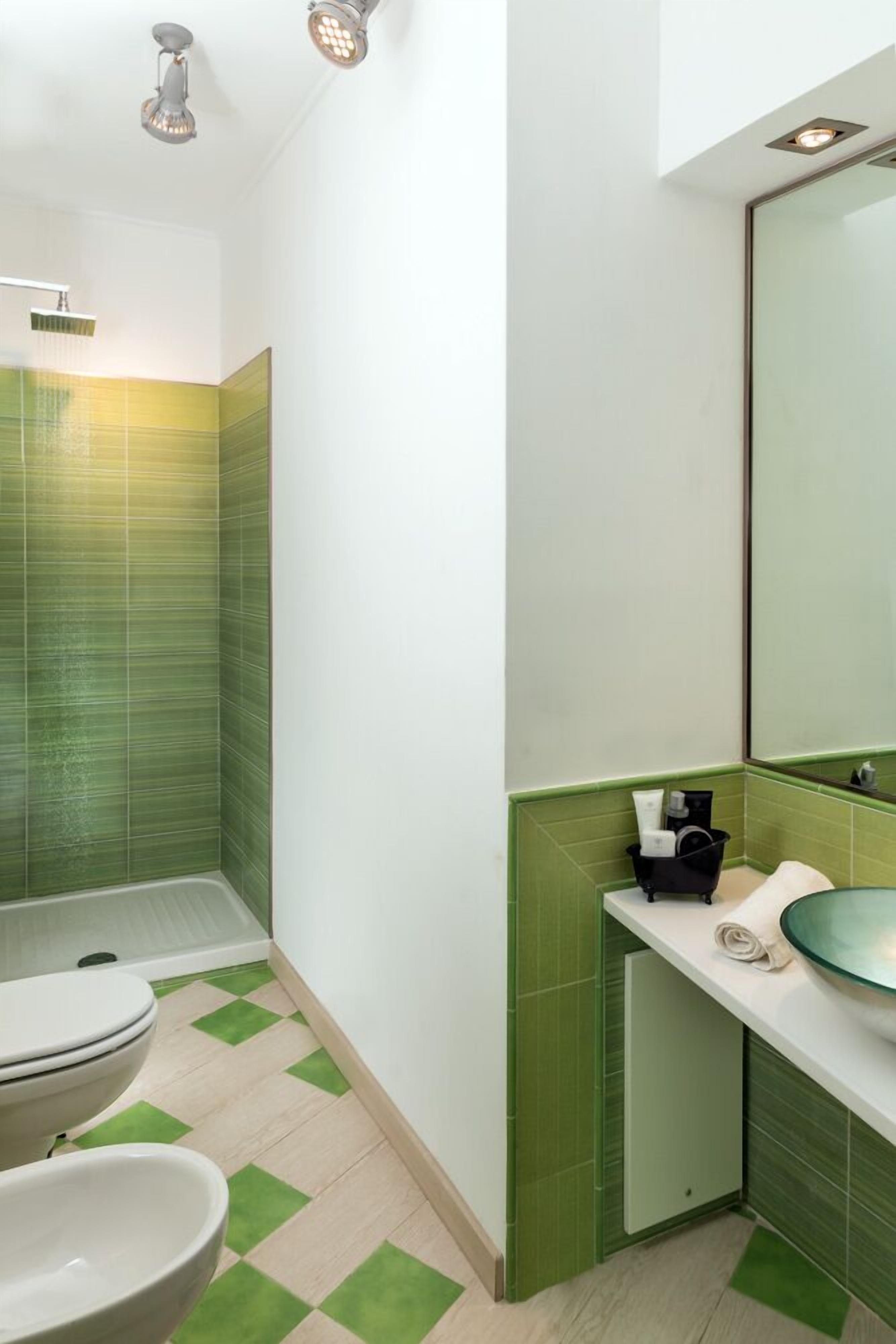A bathroom with a shower, toilet, and sink.