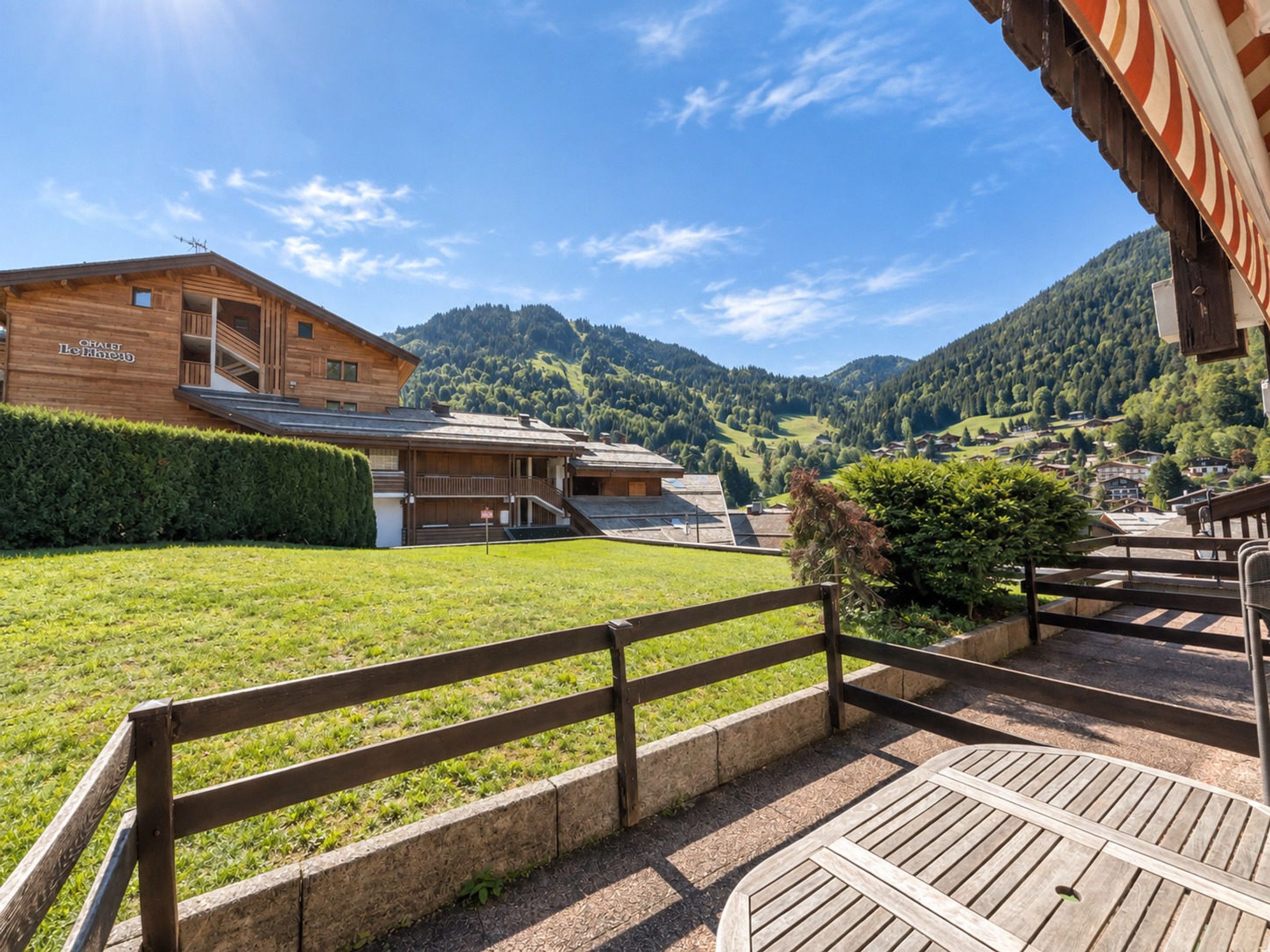 Un bâtiment en bois doté d’un balcon et offrant une vue sur un paysage montagneux.