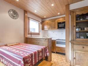 A compact kitchen with wooden cabinets, a microwave, and a stove.
