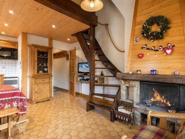 Un ambiente accogliente con una scala in legno, un camino e un angolo cottura.