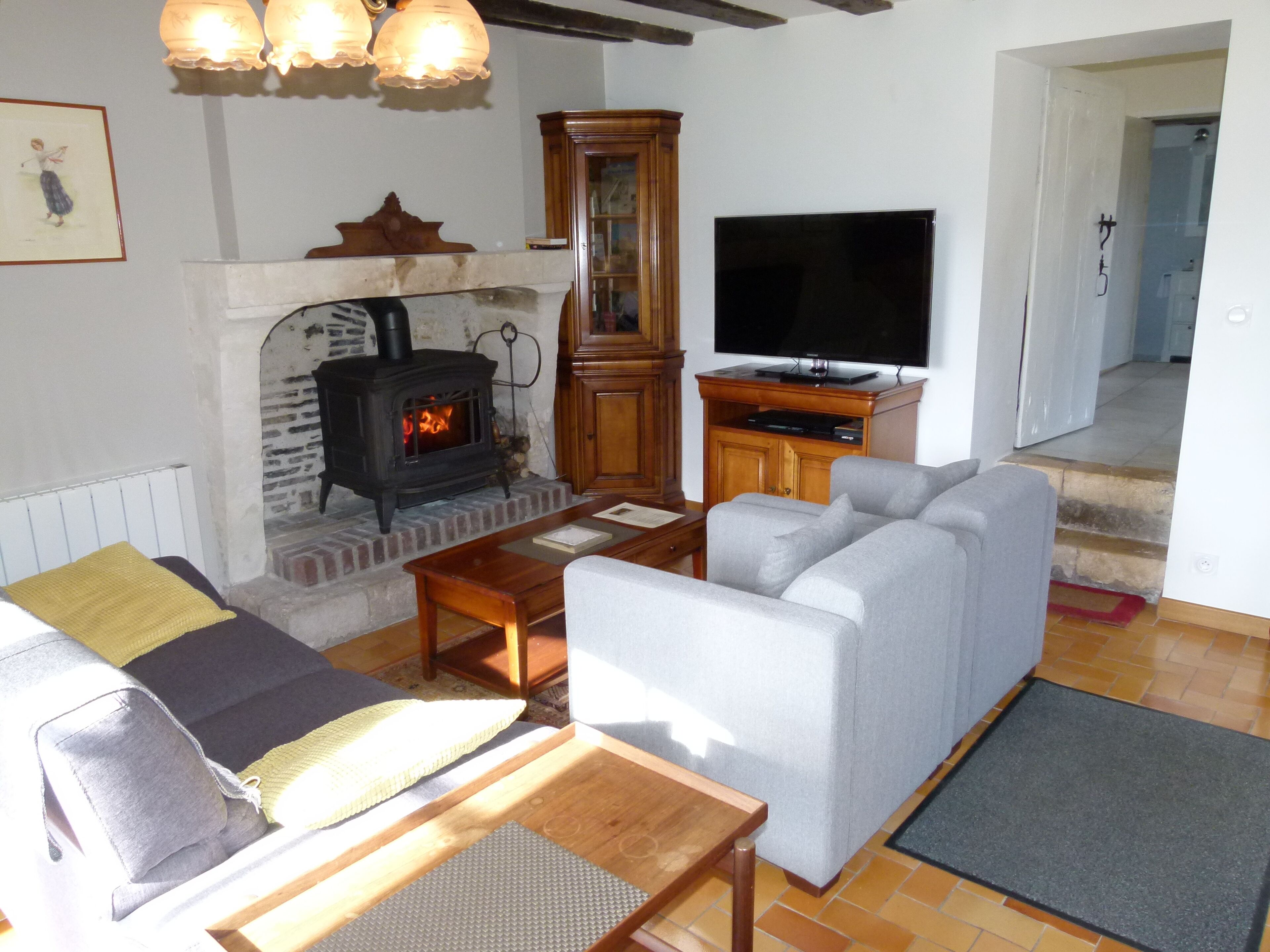 Una sala de estar acogedora con chimenea, televisor y asientos cómodos.