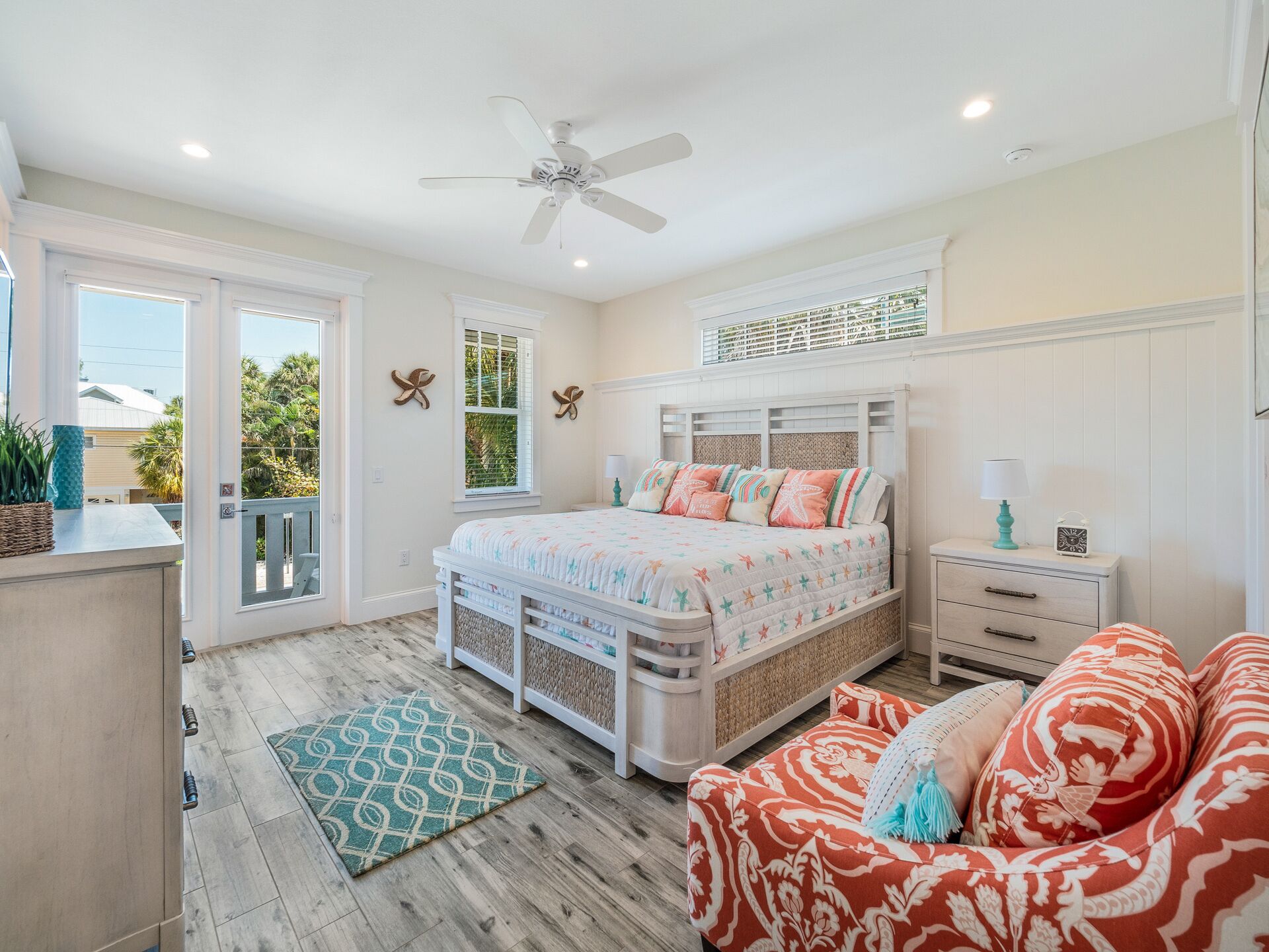 A bedroom with a bed, a nightstand, a dresser, a window, and a ceiling fan.