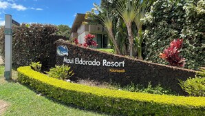 Une enseigne pour le Maui Eldorado Resort, avec un mur en pierre et un aménagement paysager de style tropical.