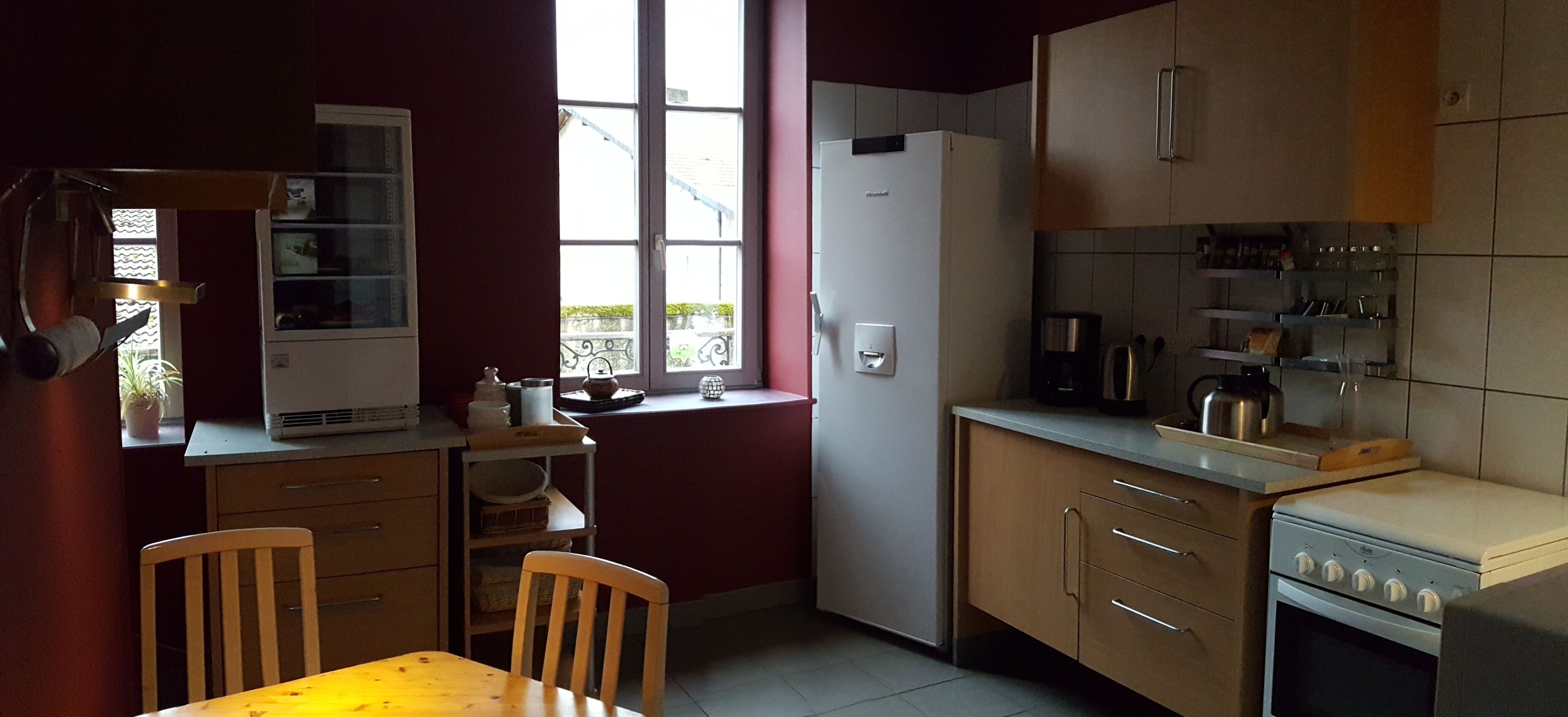 A compact kitchen with a dining area, featuring a refrigerator, stove, and various kitchen appliances.