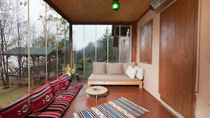 A room with a sofa, a round coffee table, and a patterned rug. - Karaca Dag Evleri (Basiskele)