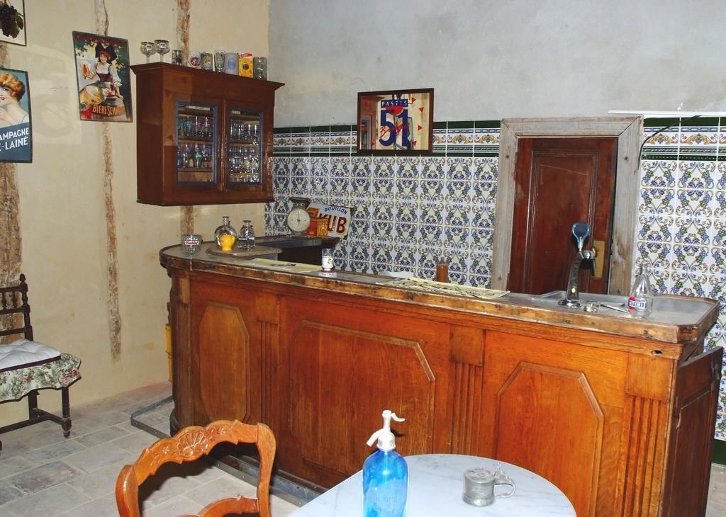 Una cocina con mostrador de madera, un reloj y una botella de desinfectante de manos.