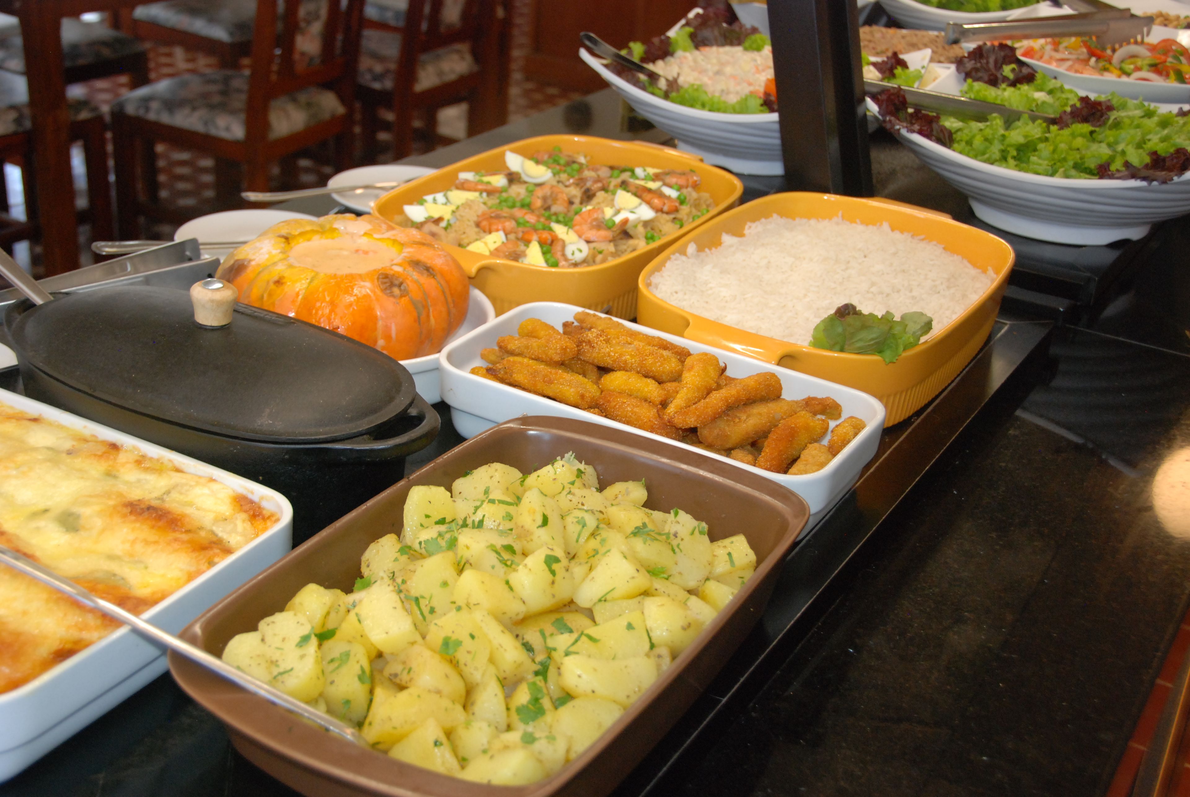 Una mesa de buffet con diversos platos, incluyendo arroz, patatas y una calabaza.