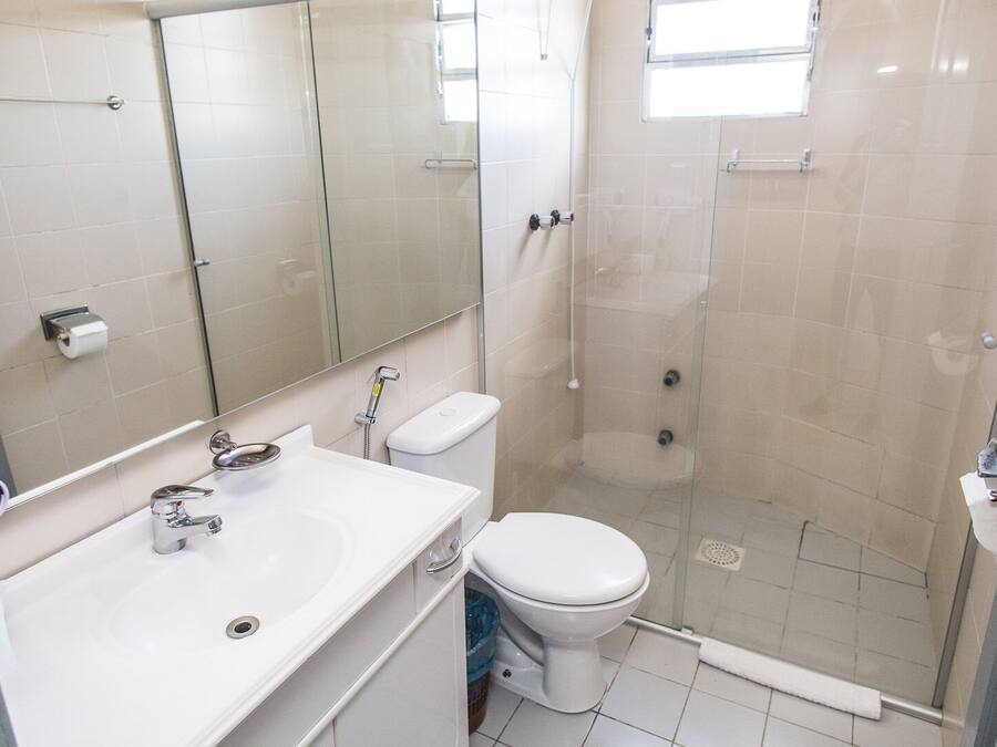 Ein Badezimmer mit Dusche, Toilette, Waschbecken und Spiegel.