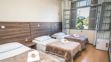 Une chambre d’hôtel avec deux lits, une fenêtre avec des rideaux et un minibar.