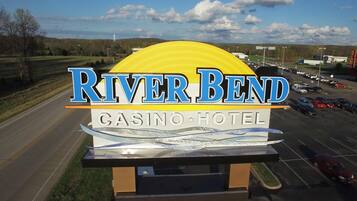 A sign for River Bend Casino Hotel with a large yellow arch and blue lettering.