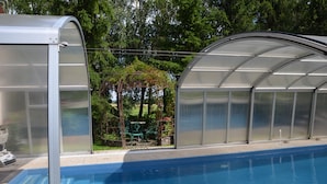 A swimming pool with a greenhouse structure adjacent to it. - Dworek Mazurski Lizer (Pozezdrze)
