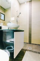 Un baño moderno con un lavamanos grande, un espejo y una zona de ducha.