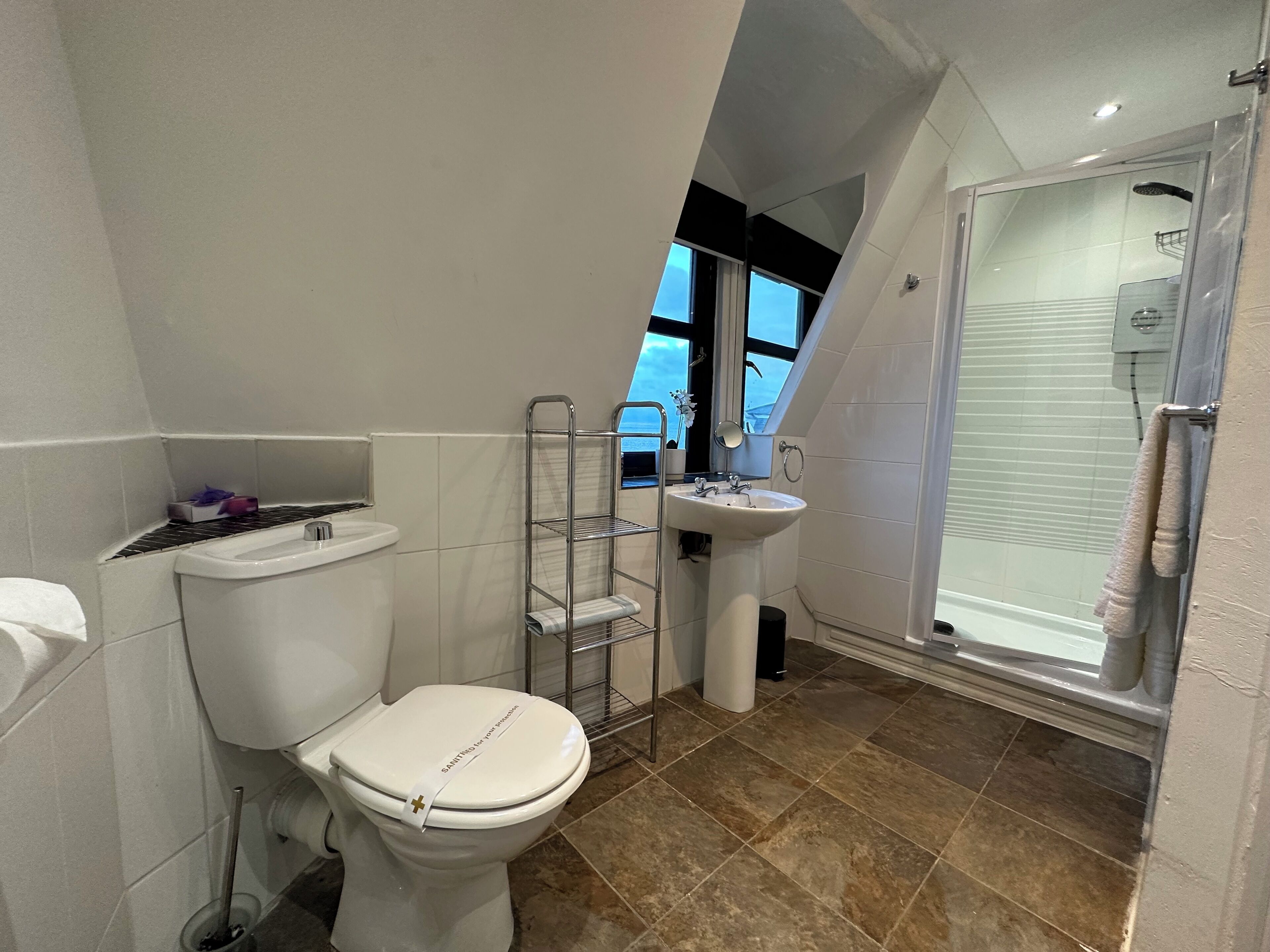 Un baño moderno con inodoro, lavamanos y ducha.
