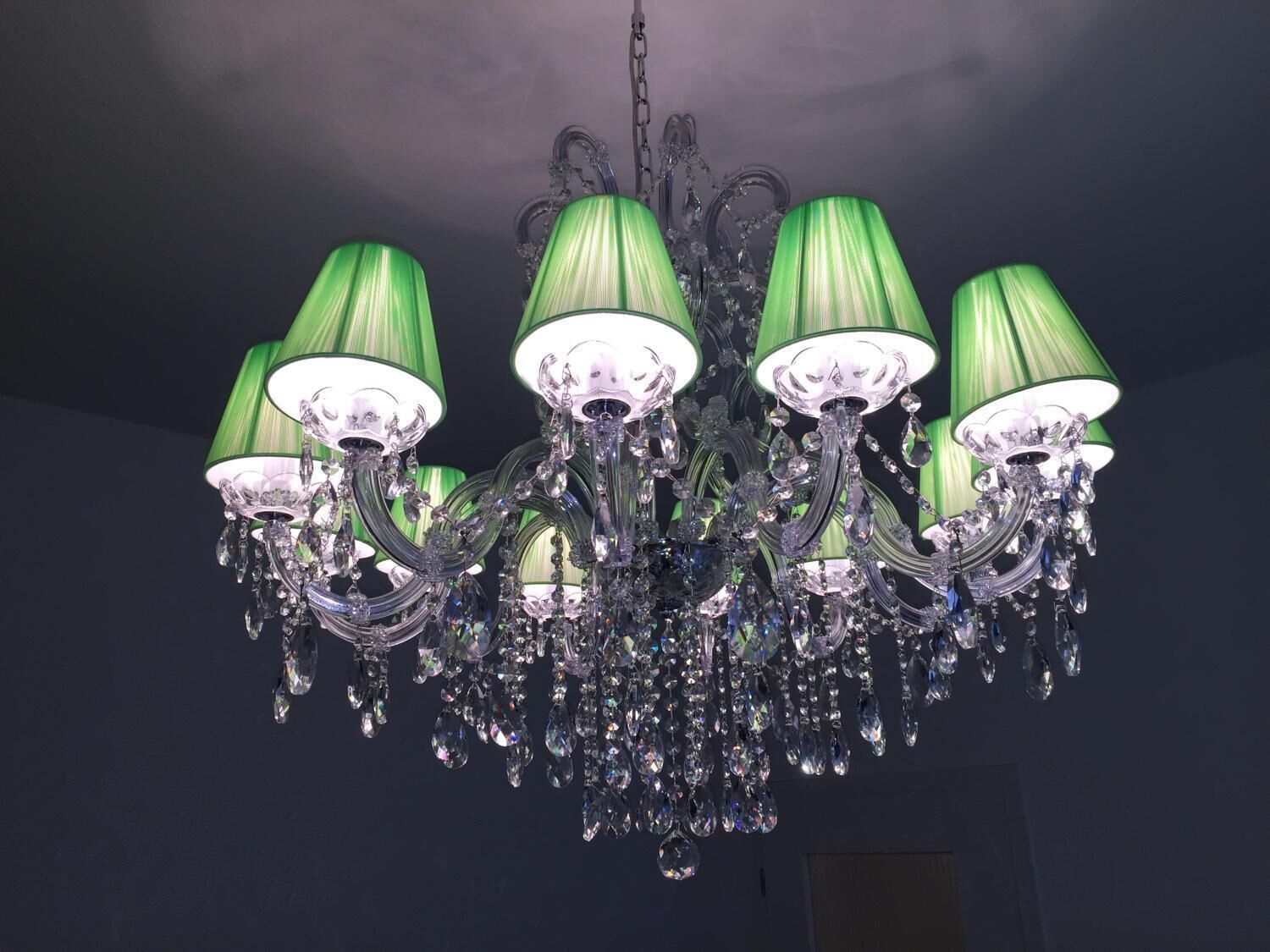 Un candelabro con múltiples pantallas y adornos de cristal.