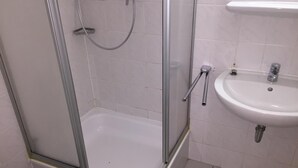 A bathroom with a glass-enclosed shower, a white sink, and a toilet. - Elbsandstein Apartment Altstadt (Erfurt)
