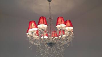 Un candelabro con múltiples brazos y lámparas de pantalla roja.