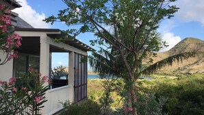 A house with a covered porch, a view of a lake, and a mountain in the background. - 2 Bedroom Bungalow-Style Villa (Basseterre)