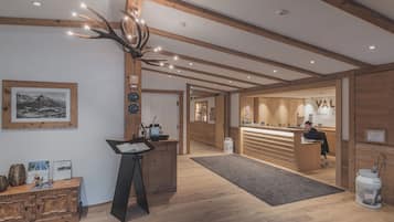 A reception area with wooden beams, a reception desk, a framed picture on the wall, and a sign with the word "VAL".