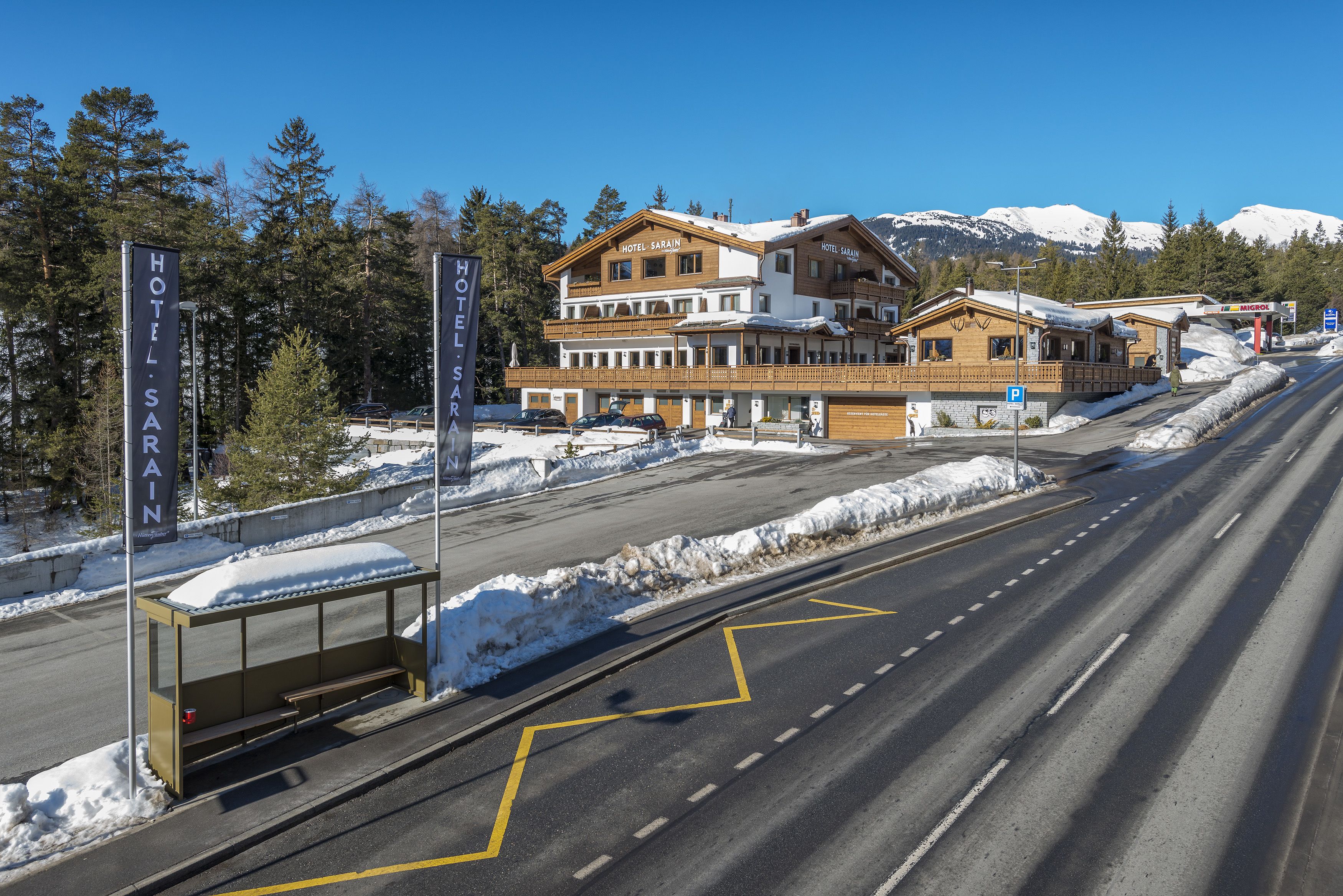 Un hotel con un edificio principale e un corpo secondario, entrambi con segnaletica ben visibile.