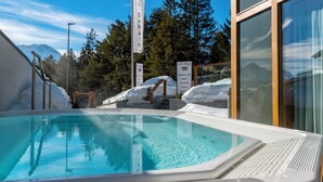 A swimming pool with a view of mountains, a wooden deck, and a sign for Hotel Sarain. - Hotel Sarain - Val Saraina Resort Lenzerheide (Lantsch-Lenz)