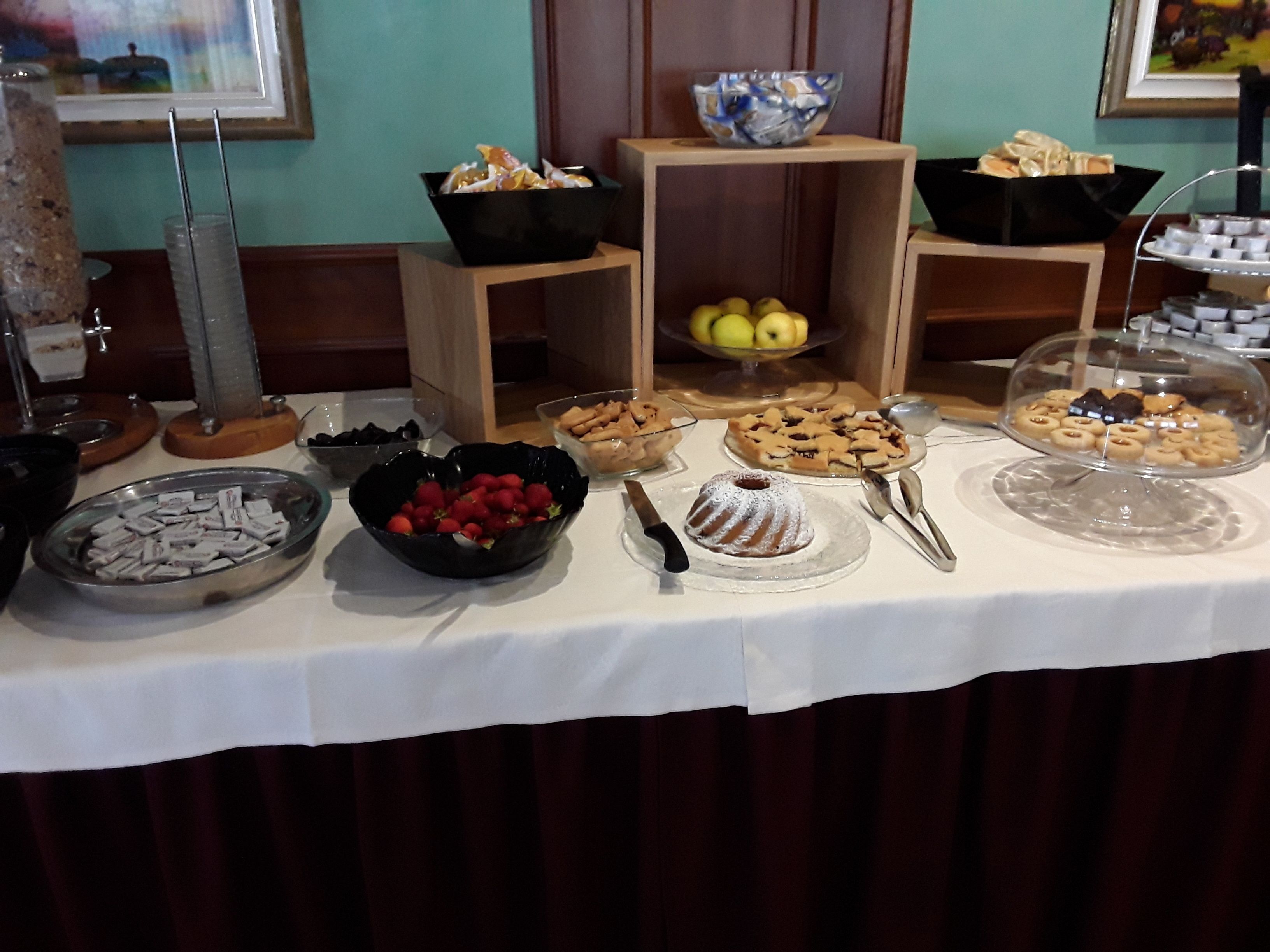 Un tavolo per buffet con diversi cibi e una ciotola di fragole.