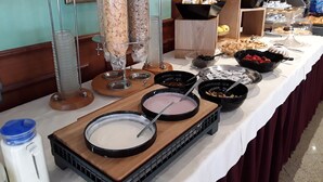 A buffet table with various food items and serving utensils. - Hotel Bellaria (Levico Terme)