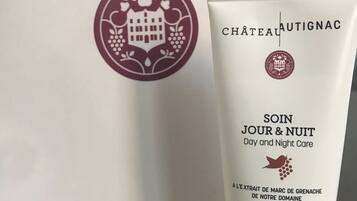 A skincare product tube and a white shopping bag with a logo.