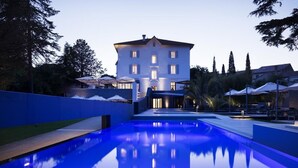 A swimming pool with a reflection of a building and trees in the background. - Château Autignac (Autignac)
