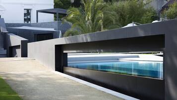 A modern pool area with a sleek, dark-colored wall and a clear view of the pool.