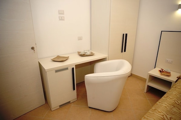 A compact bathroom with a white sink, a white toilet, and a small bedside table with a book. - Bed & Breakfast Villa Corallo (Porto Cesareo)