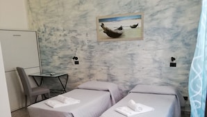 A hotel room with two beds, a desk, and a chair. - La Maison di Luca (Verona)