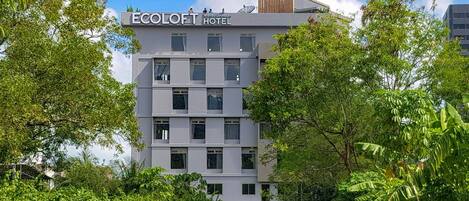 Un hotel moderno a più piani, immerso nel verde.